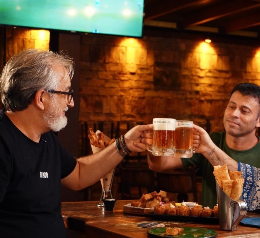 Amigos brindando com chope gelado no Boi Vindo, futebol na TV